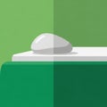 A white oval stone or object is placed on a green and white geometric base Royalty Free Stock Photo