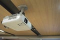 A white overhead projector on wooden ceiling in meeting room