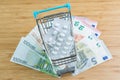 White package medicine or pills in miniature shopping cart or trolley on pile of Euro banknotes money on wood table with copy Royalty Free Stock Photo