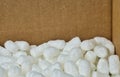 White packing peanuts styrofoam popcorn packaging material inside a cardboard box.