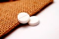 white painkiller pills on a small jute bag background Royalty Free Stock Photo