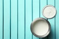 White paint can on blue wooden background, top view. Royalty Free Stock Photo