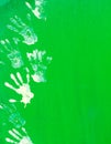 White paint hand print on green metal wall.