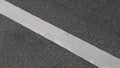 White paint line on asphalt road surface, with gray color guidelines on street Royalty Free Stock Photo