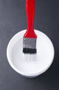 Vetical shot of can with white paint and paint brush on the black surface Royalty Free Stock Photo