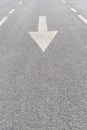 White painted arrow on grey asphalt road