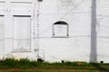 white painted brick wall building alley factory warehouse boarded windows abandoned shut closed empty city street facade Royalty Free Stock Photo