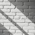 White painted brick wall with distinct shadows creating diagonal patterns across the Royalty Free Stock Photo