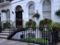 White Painted London Townhouse, With Hanging Baskets Of Summer Flowers