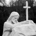 Old statue of Jesus Christ praying by the cross Royalty Free Stock Photo