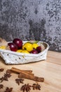 A white painted wicker basket with some ripe yellow plums Royalty Free Stock Photo