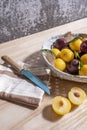 A white painted wicker basket with some ripe yellow plums along Royalty Free Stock Photo