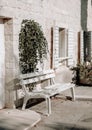 White painted wooden bench in shade in front of a stone house under  flower in summer. Travel Croatia Royalty Free Stock Photo