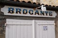 White panel in facade street shop with opening time hours text in french brocante translation means in english antiquities store