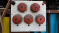 White panel with old five red fire alarm, the controls are associated with safety mechanisms or emergency functions Royalty Free Stock Photo
