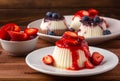 White panna cotta with strawberry in a dish on a wooden background