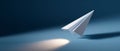White paper airplane flying over blue surface with spotlight and shadow in minimalistic composition Royalty Free Stock Photo