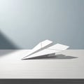 A white paper airplane rests on a flat light colored surface Royalty Free Stock Photo