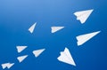 White paper airplanes against the blue sky. The symbol of freedom and privacy on