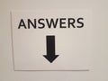 White paper answers sign with black down arrow on wall Royalty Free Stock Photo