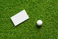 White paper background and golf ball on green grass of golf course background. Royalty Free Stock Photo