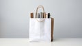 A white paper bag with books inside on a gray background. This image shows a white paper bag with a brown handle and Royalty Free Stock Photo