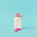 White paper bag with silver dress and pink high heels against blue pastel background. Happy shopping girl concept.Copy space Royalty Free Stock Photo