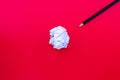 White paper ball with a black pencil on a red background. Royalty Free Stock Photo