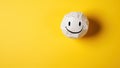 White paper ball with smiley face on yellow background. Minimal concept Royalty Free Stock Photo