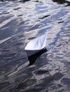 White paper boat on the blue water surface. Royalty Free Stock Photo