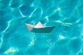 White paper boat, origami paper ship into the clear sea water. Royalty Free Stock Photo