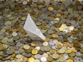 Origami ship shipwrecked in russian coins of various denominations: rubles and kopecks. Selected focus.