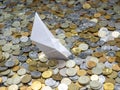 Origami ship shipwrecked in russian coins of various denominations: rubles and kopecks. Selected focus.