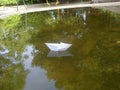 White paper boat at stale water in garden Royalty Free Stock Photo