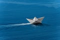 White paper boat with wake in the blue sea - Aerial view Royalty Free Stock Photo