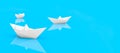 paper boat sailing. white paper boats on a bright blue surface - perfect serenity - confidently keep afloat metaphor