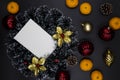 White paper card in Christmas wreath on black background. Blank card with text place. Christmas wreath top view Royalty Free Stock Photo