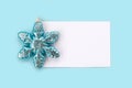 White paper card decorated with snowflakes on light blue background. Royalty Free Stock Photo