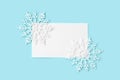 White paper card decorated with snowflakes on light blue background. Royalty Free Stock Photo