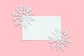 White paper card decorated with snowflakes on pink background. New Year, Christmas and winter concept. Flat lay, top view, free Royalty Free Stock Photo