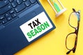 White paper with text TAX SEASON in male hands on a white background