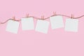 White paper cards on clothes-pegs on pink background Royalty Free Stock Photo
