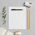 White paper centered on a gray concrete surface with a black pen on top. A wooden Royalty Free Stock Photo