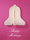 White paper Christmas bell ornament against a pink background Royalty Free Stock Photo