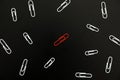 White paper clips and red one on black background Royalty Free Stock Photo