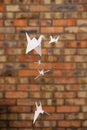 White paper cranes japanese symbol of longevity of a brick wall