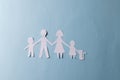 White paper cut out of family with two children and cat and copy space on blue background Royalty Free Stock Photo