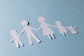 White paper cut out of family with two children and cat and copy space on blue background Royalty Free Stock Photo