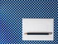 White paper envelope and black pencil on a blue background polka Royalty Free Stock Photo