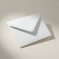 A white paper envelope with a triangular flap is placed on a light, neutral-colored surfa Royalty Free Stock Photo